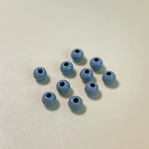Detalle de cuentas redondas azul claro brillantes con orificio central para joyería DIY