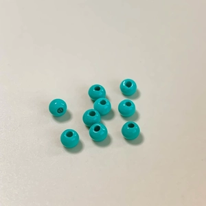 Vista macro de cuentas redondas de aleación lacada verde pavo real para joyería DIY