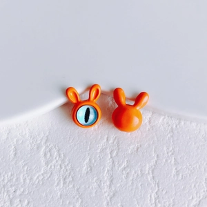 Macro shot of cute orange bunny DIY beads with blue cat-eye pupil and smooth texture