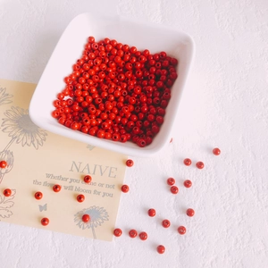 Cuentas redondas de aleación esmaltada rojo vibrante en un cuenco para joyería DIY