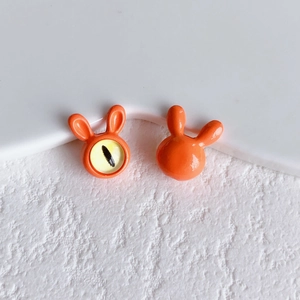 Close-up of cute orange rabbit beads with glossy finish and evil eye detail for DIY jewelry