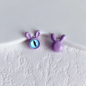 Detail view of purple rabbit charm featuring blue eye inlay and smooth enamel finish