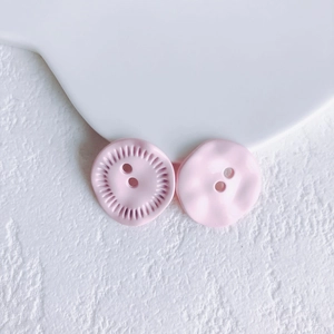 Macro detail of pink flower button pendants with matte finish for DIY jewelry crafting