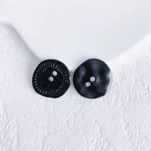 Detailed view of two vintage black textured buttons for DIY handmade jewelry crafting