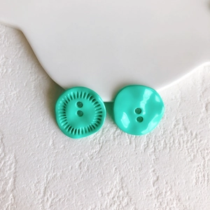 Macro shot of mint green decorative buttons with wavy textures for DIY sewing and jewelry