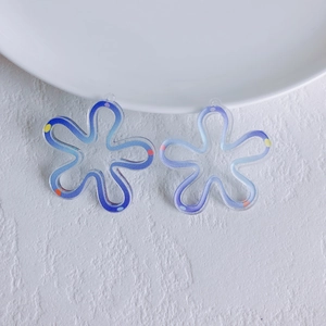 Close-up of acrylic flower charms with blue-purple gradient and colorful polka dots