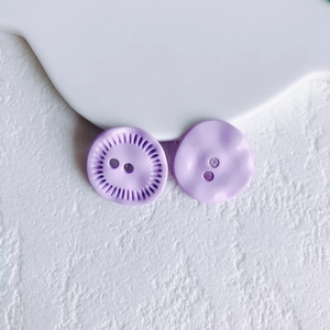 Macro detail of purple flower alloy buttons with radial texture for DIY jewelry making