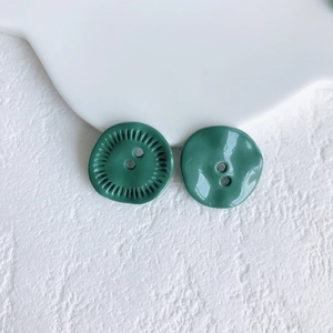 Macro detail of dark green vintage alloy buttons with textured edges and smooth resin finish