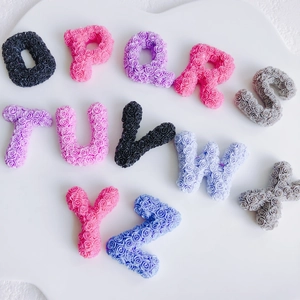 Flat lay of resin alphabet letters O to Z with detailed floral rose relief texture