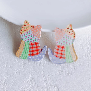 Detail of DIY acrylic kitten charms with colorful floral and plaid patterns