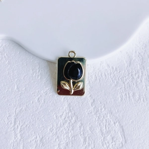 Detail of rectangular tulip pendant with gold base and black floral enamel inlay