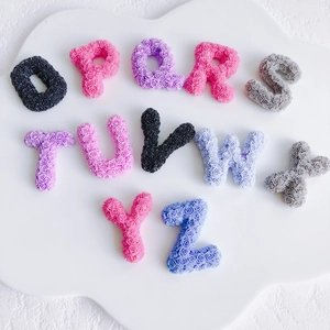 Macro shot of 3D colorful resin alphabet letters with delicate rose petal texture
