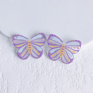 Macro shot of purple acrylic butterfly beads with yellow dots for DIY jewelry making