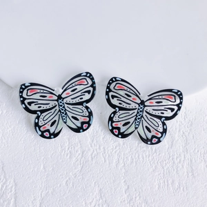 Macro view of patterned acrylic butterfly charms with pre-drilled holes for DIY jewelry