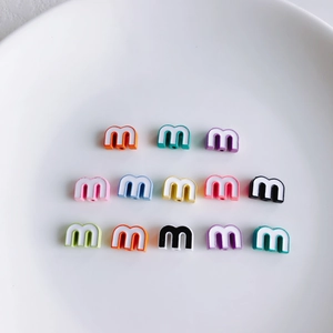 Macro shot of colorful letter M beads for DIY jewelry with straight thread holes