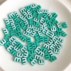 Macro shot of mint green alphabet beads with letter M for DIY jewelry and crafts