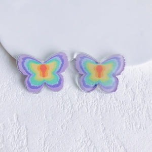 Close-up of DIY acrylic butterfly charms with vibrant rainbow printed gradient patterns