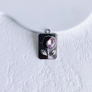 Macro shot of rectangular tulip pendant with pink teardrop crystal and brushed metal finish