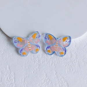 Close-up of colorful butterfly acrylic DIY charms with hand-painted patterns and top holes