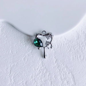 Detailed heart shaped silver pendant with a green pear-cut gemstone and white zircons