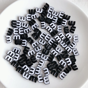 Close-up of black and white candy-colored letter M beads for DIY jewelry making