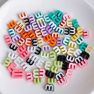 Macro shot of colorful letter E beads for DIY jewelry making in various pastel shades