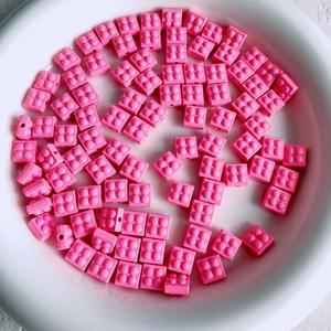 Macro shot of 2x2 macaron pink block beads for DIY jewelry and phone chain making