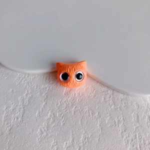 Makroaufnahme der orangefarbenen Katzenkopf-Harzperle für DIY-Schmuck mit Fellstruktur