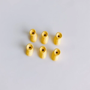 Detailed view of yellow macaron boot-shaped charms with drill holes for DIY crafts