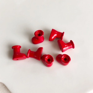 Detail view of seven red macaron style mini boot charms for DIY jewelry making
