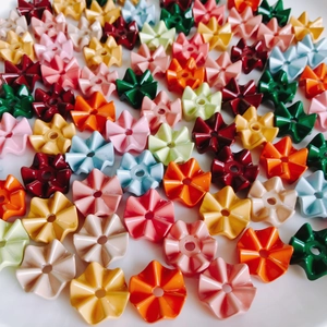 Primer plano de cuentas de flores de acrílico coloridas con agujero central para joyería DIY