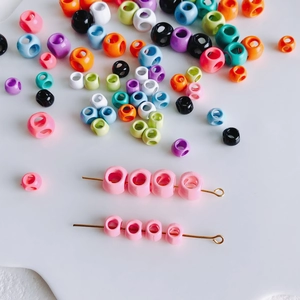 Gekleurde legeringskralen met meerdere gaten voor DIY-sieraden op wit vlak