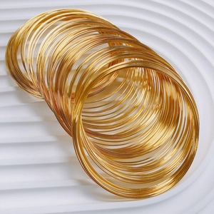 Set of multilayer golden memory wire bangles with minimalist thin metal stackable design