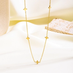 Gold minimalist titanium necklace featuring five elegant four-pointed star charms