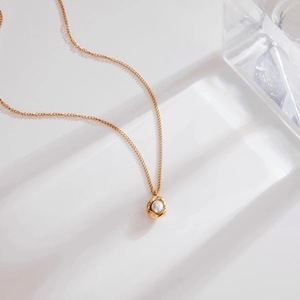 Elegante collana placcata oro con perla d'acqua dolce e ciondolo a conchiglia a spirale