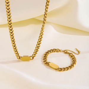 Golden titanium steel chunky Cuban link necklace and bracelet set on soft satin fabric
