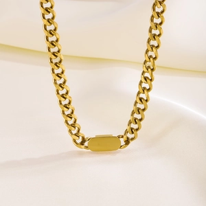 Minimalist chunky golden Cuban link chain necklace on soft white silk background