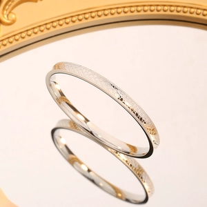 Silver dragon scale titanium steel bangle with milgrain edges on reflective surface