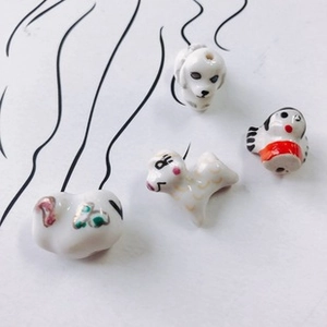 Macro shot of assorted DIY ceramic lucky cat beads and animal charms for jewelry making