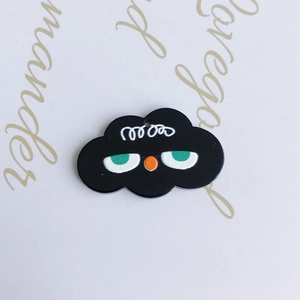 Close-up of black cloud charm with cartoon facial features for DIY jewelry projects
