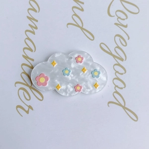 Detail of cloud-shaped DIY charms with colorful abstract floral oil painting patterns