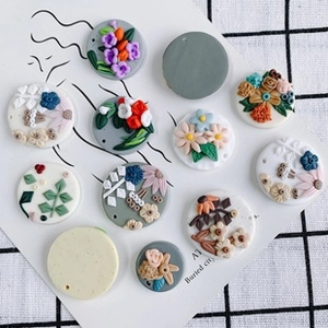 Macro-opname van 3D bloemenklei bedeltjes op kaarten voor DIY-sieraden