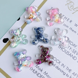 Detailed view of colorful resin bear charms filled with sparkling sequins for DIY crafts