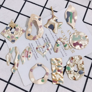 Detailopname van twaalf geometrische goudkleurige en emaille bloem sieraden hangers