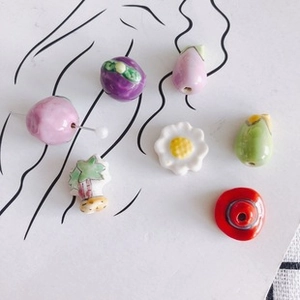 Close-up of colorful ceramic beads in varied shapes including fish and flowers for DIY jewelry