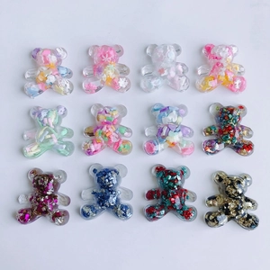 Flat lay of 12 colorful resin bear charms with glitter filling for DIY jewelry making