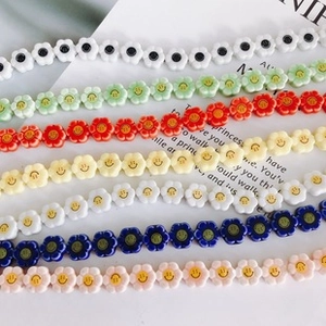 Colorful flower-shaped beads with smiley faces for DIY jewelry and crafts