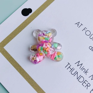 Macro view of transparent resin bear charm with colorful sprinkles for DIY crafts