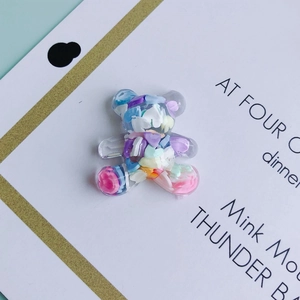 Macro shot of translucent resin bear charms with colorful sequin fillers for DIY crafts