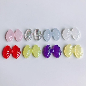 Detailed macro view of eight colorful translucent resin bow charms for DIY jewelry making